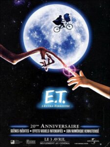 Affiche du film E.T. l'Extra-Terrestre. Une pleine lune éclaire la silhouette d'un enfant à vélo volant, accompagné d'une créature, au centre de l'image. Au premier plan, deux doigts lumineux se touchent, l'un appartenant à une main humaine et l'autre à une main extraterrestre.